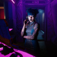 Cyberpunk 2077 receptionist for the Clouds brothel checking in a guest at the computer.